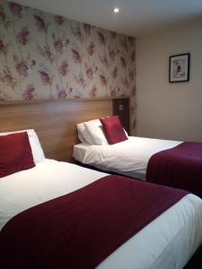 a hotel room with two beds and two lamps at Weald of Kent Golf Course and Hotel in Headcorn