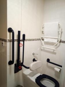 a bathroom with a white toilet and a black seat at Weald of Kent Golf Course and Hotel in Headcorn