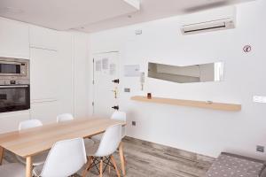 a dining room with a wooden table and white chairs at Loft Beta in Castellón de la Plana