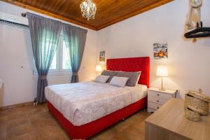1 dormitorio con 1 cama con cabecero rojo en Vista Del Mare Luxury Villa, en Koinira