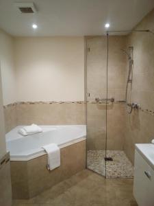 La salle de bains est pourvue d'une baignoire et d'une douche. dans l'établissement Weald of Kent Golf Course and Hotel, à Headcorn