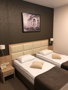 ヒムキにあるIskra Hotelのベッド2台が備わる客室で、壁に絵が描かれています。
