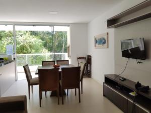 eine Küche und ein Esszimmer mit einem Tisch und Stühlen in der Unterkunft Bombinhas SC 200 metros da Praia in Bombinhas