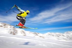 um homem a voar pelo ar enquanto monta esquis em SNOW HOUSE em Rivisondoli