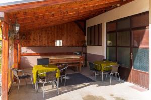 a patio with two tables and chairs and a piano at Guest house Padine Zlatibora in Zlatibor
