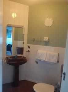a bathroom with a sink and a mirror and a toilet at Shalom in Carlingford