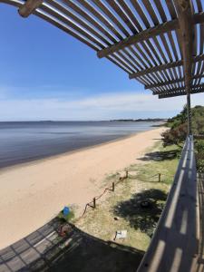 a view of the beach from the porch of a beach house at Eugenio Araus Apartamento 504 in Colonia del Sacramento