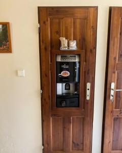 a microwave in a wooden cabinet in a room at Penzion Pod Zámkem in Pruhonice
