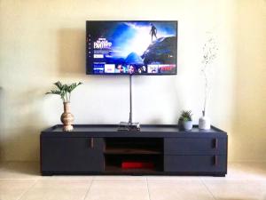 a black entertainment center with a flat screen tv on a wall at Cozy studio in Cebu IT Park in Cebu City