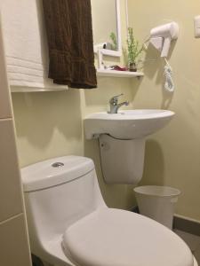 a bathroom with a white toilet and a sink at Cozy studio in Cebu IT Park in Cebu City