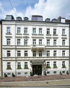 a large building with a clock on the front of it at Boutique Hotel Splendid-Dollmann in Munich