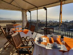 restauracja ze stołami i krzesłami na balkonie w obiekcie Annunziata Bed and Breakfast w mieście Napoli