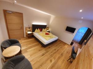een slaapkamer met een bed en een tafel en stoelen bij Hotel Mignon in Solda