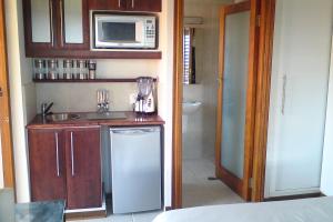 uma pequena cozinha com um lavatório e um micro-ondas em Jakita's Guest house em Ballito