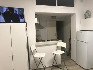 cocina con 2 sillas blancas y nevera blanca en Estudio La Concepción, en La Laguna