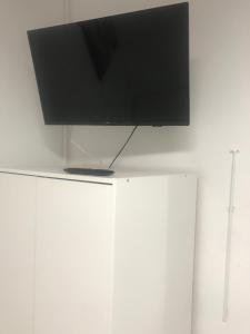 TV de pantalla plana sobre armarios blancos en Estudio La Concepción, en La Laguna