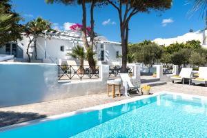 a villa with a swimming pool and a house at Santorini Kastelli Resort in Kamari