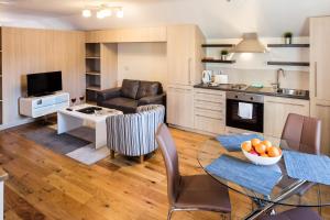 una cucina e un soggiorno con tavolo e divano di Baggotrath House Apartments, Newbridge Ave, Dublin 4 a Dublino