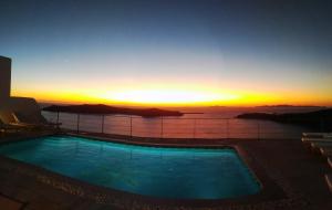 una piscina en la parte superior de un edificio con puesta de sol en Absolute Bliss en Imerovigli