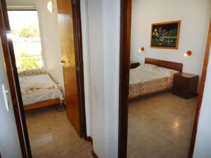 Pokój z sypialnią z łóżkiem i oknem w obiekcie Hotel Reviens w mieście Villa Gesell