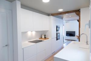 a kitchen with white cabinets and a tv at Next city center San Sebastian Bus & Train Station Free wifi in San Sebastián