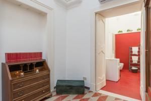 a room with a wooden dresser and a red wall at Palazzo Le Cupole by Wonderful Italy in Ostuni