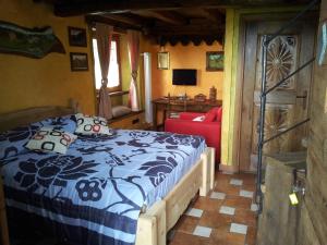 1 dormitorio con 1 cama y 1 silla roja en Affittacamere Saint Salod, en Charvensod