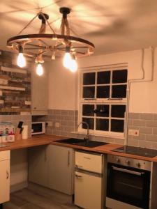 a kitchen with a sink and a ceiling at Fisherman’s Cottage in Y Felinheli