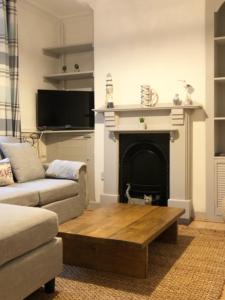 a living room with a couch and a fireplace at Fisherman’s Cottage in Y Felinheli