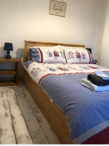 a bedroom with a bed with a blue and white comforter at Fisherman’s Cottage in Y Felinheli