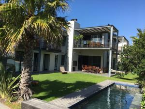 a house with a palm tree and a swimming pool at Sunset-Loft in Cape Town