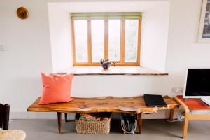 バラにあるThe Barn at Ty Beicの木製テーブルと窓が備わる客室です。