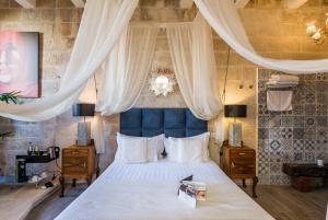 a bedroom with a large bed with a blue headboard at Valletta Lucente Guest House in Valletta