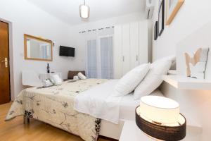a white bedroom with a large bed with white pillows at Villa Veca in Starigrad