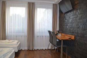 Habitación de hotel con mesa y cama en Villa Vip, en Gniezno