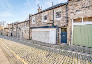 una calle adoquinada con edificios con garajes en The Gloucester Lane Residence, en Edimburgo