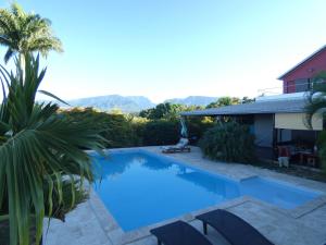 a large blue swimming pool in front of a house at villabellevue in Saint-Pierre