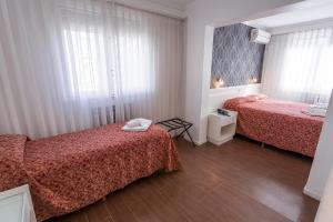 a hotel room with two beds and a window at Estocolmo Hotel by bund in Mar del Plata +21 photos