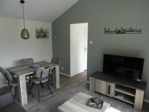 een woonkamer met een tafel en een televisie bij Vakantiewoning 't Steechje in Hollum