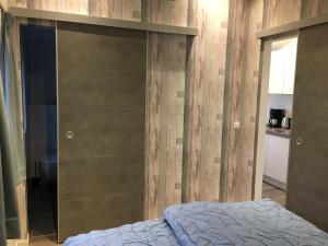 - une chambre avec un lit et un mur en bois dans l'établissement Vakantiewoning 't Steechje, à Hollum