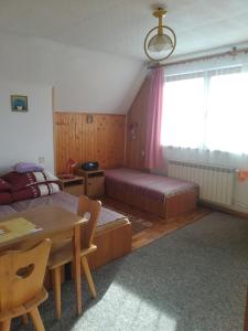 pokój z dwoma łóżkami i stołem w obiekcie Pokoje u Tadeusza w Zakopanem