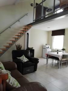 a living room with a couch and a staircase at The Mill 2380 in Ravels