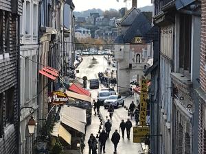 un grupo de personas caminando por una calle de la ciudad en Le Studio du Gouverneur, en Honfleur