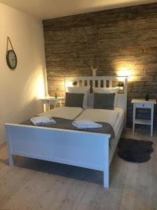 - une chambre avec un grand lit blanc et des murs en bois dans l'établissement Apartamenty Sudeckie nad zalewem, à Sosnówka