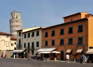 a street with a tower and a building with a clock tower at Il Campanile B&B in Pisa