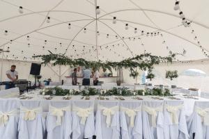a white tent with a table with white bows at Meduza Hotel in Palanga
