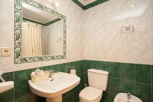 a bathroom with a sink and a toilet and a mirror at Hostal Vinuesa in Vinuesa