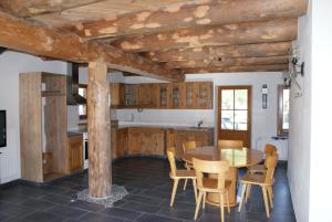 una cocina con armarios de madera, mesa y sillas en Charmante Ferienwohnung im Landhausstil en Kašperské Hory