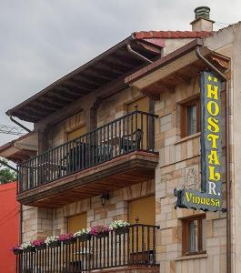 - un bâtiment avec un balcon et un panneau sur celui-ci dans l'établissement Hostal Vinuesa, à Vinuesa