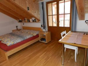 1 dormitorio con cama, escritorio y mesa en Charmante Ferienwohnung im Landhausstil en Kašperské Hory